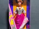 doll in the box is wearing a pink dress and holding a comb