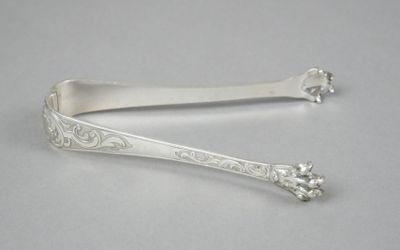 pair of silverware spoons with floral designs on them on a white surface