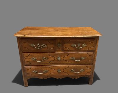 a wooden chest of drawers with ornate carvings and brass handles