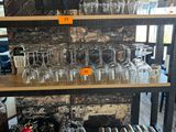 une étagère sur laquelle sont posés des verres à vin et des bouteilles