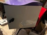 a white refrigerator with a purple lid sitting on a chair