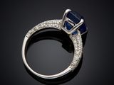 a blue sapphire and diamond ring on a black surface