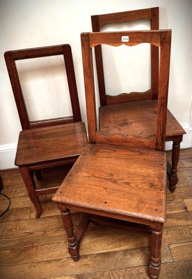 two wooden chairs sitting next to each other on a hard wood floor