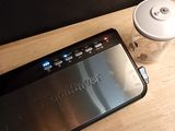 a coffee cup next to a cell phone on a table