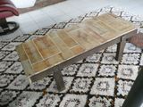 a wooden bench sitting on a rug in a living room