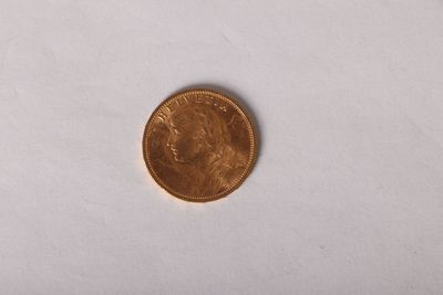 a close up of a coin sitting on top of a white surface