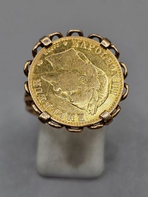 a gold ring with a coin in the middle of it