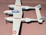 deux maquettes d'avion posées sur une table, sur un fond marron