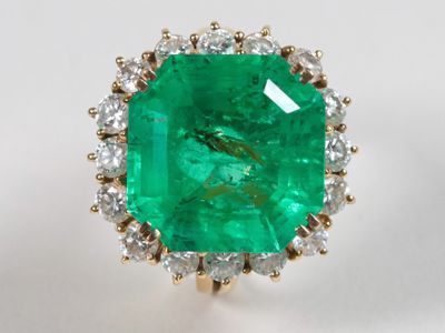 un gros plan d'une bague en émeraude et diamants