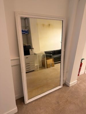 un grand miroir dans le coin d'une pièce