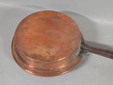 a small copper pot with a wooden handle