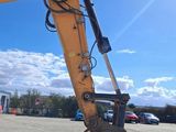 a yellow excavator that is parked in the parking lot