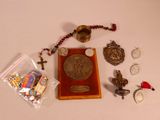de nombreux objets posés sur une table, notamment un chapelet, une médaille et d'autres objets