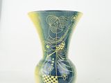 a green vase with a picture of a woman on it
