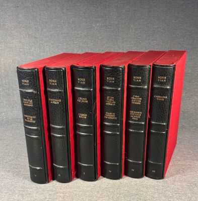 six black books are lined up in a row on a gray surface