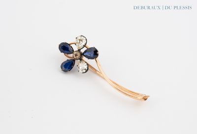 an image of a flower brooch with blue and white stones