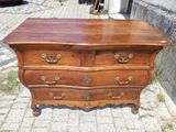 une commode en bois posée sur un trottoir en briques