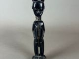 a black figurine of a man with a hat on his head