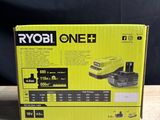 a box of ryob one + battery charger on a wooden table