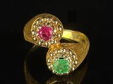a close up of two rings with different colored stones on a black surface