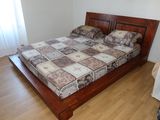 a bed with a wooden frame in a room with wood floors
