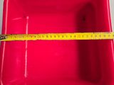 a red plastic container with a measuring tape on top of it