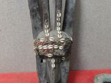 une statue représentant une main ornée d'une bague, à côté d'autres objets