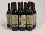 six bottles of wine are lined up in a row on a white surface