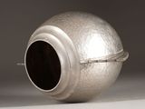 a silver vase that is sitting on a table