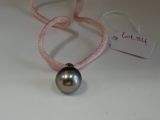 un collier orné d'une perle, posé sur une table