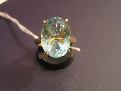 a ring with a blue topaz stone on a black surface
