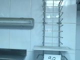 a glass counter top with a metal shelf and a sign on it