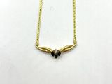 a gold plated necklace with black stones on a white background
