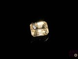 a close up of a yellow diamond on a black surface