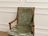 une image représentant une chaise verte posée sur un parquet en bois massif