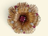 une image représentant une broche en or sertie de rubis et de diamants