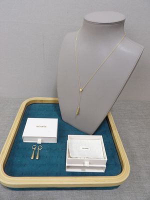 a necklace, earring, and ring on a tray
