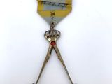 an image of a medal with a pair of scissors on top of it