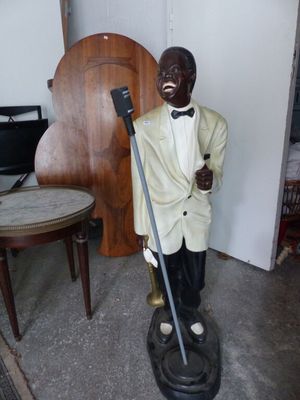 une statue représentant un homme en smoking, muni d'une canne