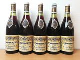 six bottles of wine are lined up on a table