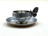 une tasse et une soucoupe en argent ornées d'un papillon