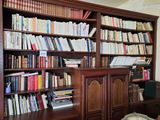 a book shelf with many books on it in a room