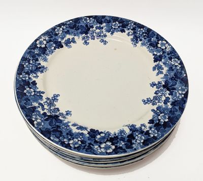 quatre assiettes bleues et blanches empilées les unes sur les autres sur une surface blanche