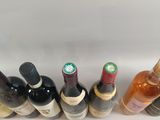 several bottles of wine are lined up in a row on a white surface