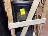 une poubelle noire posée sur un socle en bois dans un entrepôt