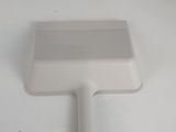 a white plastic brush and a tube of toothpaste on a white surface