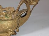 a gold teapot with a dragon handle on a white table