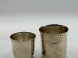 pair of silverplated cups with beaded rims on a white surface