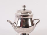 a silver teapot with a lid on a white background