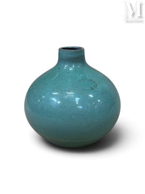 un vase bleu posé sur une surface blanche